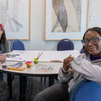 Girls of Color Summit previous event where attendees color at a table